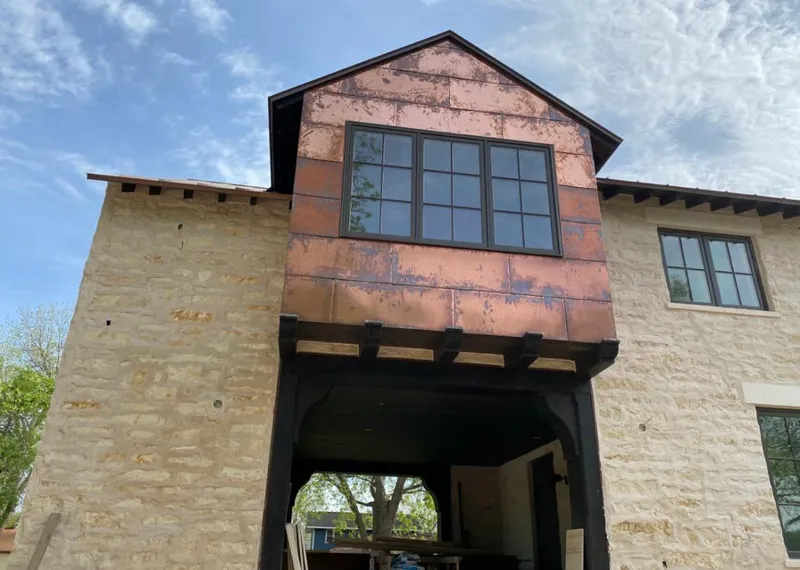 Copper metal panel facade on a stone building for Skylight Installation in Wonder Lake